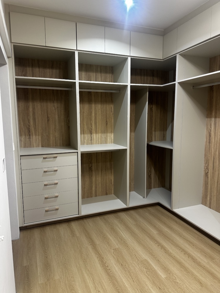 Vue d’ensemble du dressing avec penderies, tiroirs et fonds bois